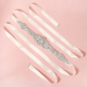 Detail of luxury bridal belt with ivory silk ribbon and sparkling rhinestone flower pattern