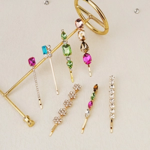 Detail view of seven-piece hair clip set featuring colorful crystals and pearls on gold clips