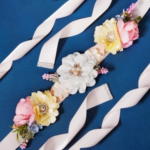 Handmade bridal sash featuring fabric flowers, pearls, and crystals on champagne ribbon