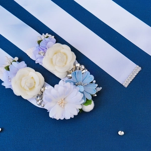 Exquisite bridal wedding sash with white silk roses and blue daisies with rhinestones