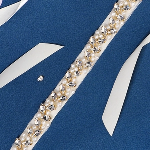 Close-up of handmade bridal belt featuring marquise rhinestones and pearls on ribbon