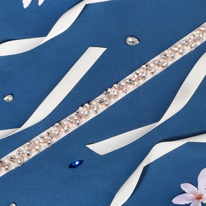 Detail of bridal belt with marquise rhinestones and white pearls on silk ribbon