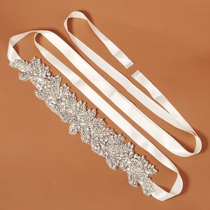 Detail showing intricate silver floral rhinestones hand-sewn on a white satin bridal belt
