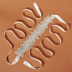Detail of bridal sash featuring hand-sewn crystals and rhinestones on a white satin ribbon