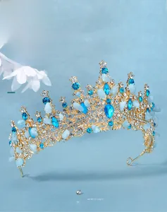 Detailed side view of handmade golden bridal crown with blue rhinestones and crystal stones