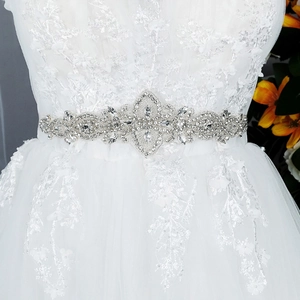 Dettaglio della cintura da sposa cucita a mano con strass argentati e cristalli di lusso a fiori