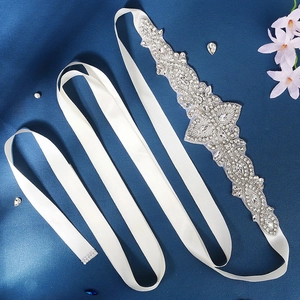 Dettaglio della cintura da sposa con strass scintillanti su nastro di raso bianco