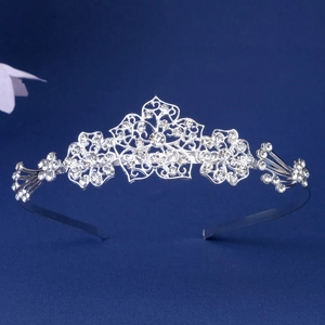 Detailed view of silver metal headband with hollow floral patterns and sparkling rhinestones