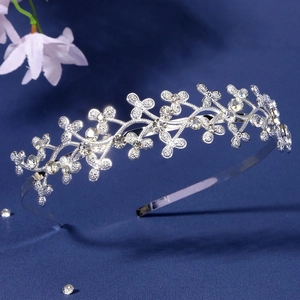 Close-up detail of silver metal headband with clover floral patterns and sparkling crystals