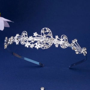 Detail view of silver metal headband with floral heart patterns and clear rhinestones