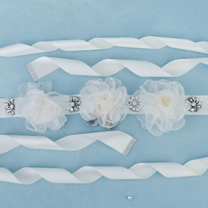 Detail of bridal sash with white chiffon flowers, sparkling rhinestones and satin ribbon