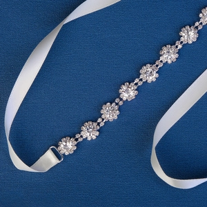 Close-up of sparkling rhinestone sunflower bridal sash with elegant white silk ribbon tie