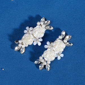 Dettaglio ravvicinato di clip per scarpe a camelia fatte a mano con perle e cristalli lucidi