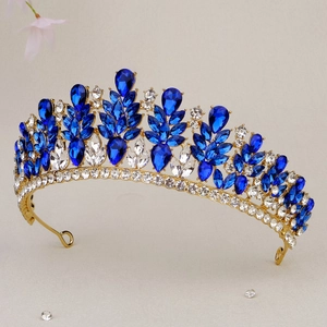 Dettaglio di una lussuosa corona da sposa dorata con cristalli blu scuro a forma di pera