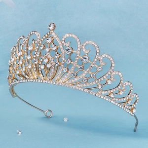 Close-up of golden bridal crown with intricate scroll patterns and sparkling rhinestones