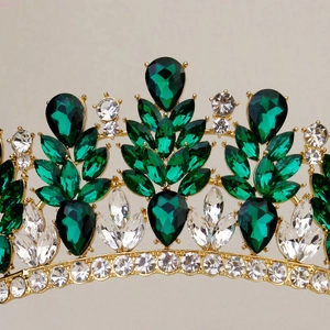 Dettaglio macro della corona da sposa dorata con cristalli verde smeraldo e strass