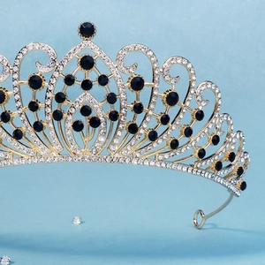 Detailed macro view of baroque gold tiara featuring black gemstones and rhinestones