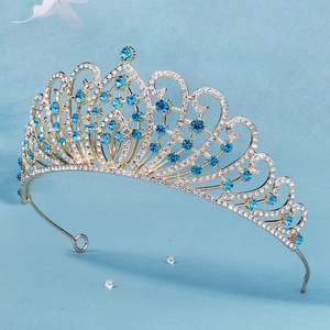Macro detail of luxury golden bridal crown with sky blue rhinestones on blue background