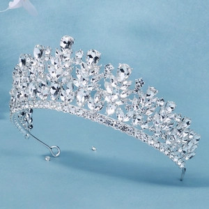 Dettaglio ravvicinato di una corona da sposa argento con cristalli scintillanti su sfondo blu