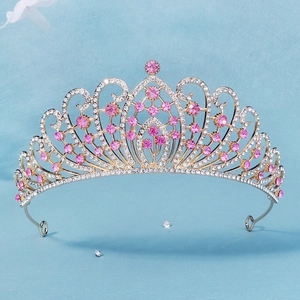Close-up of luxury bridal tiara with pink crystals and silver rhinestone patterns