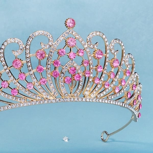 Detailed close-up of Baroque gold crown with pink crystals and shimmering rhinestones
