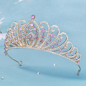 Close-up of golden bridal crown featuring purple rhinestones and baroque scrollwork