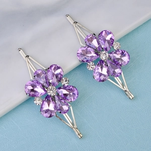 Macro shot of two floral hair clips with purple crystal petals and silver metal base