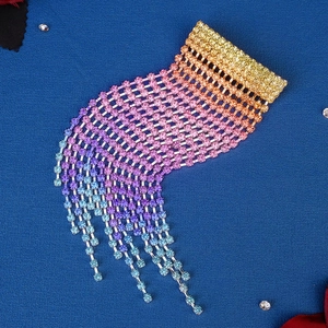 Detailed close-up of rainbow gradient crystal rhinestones with long hanging tassels