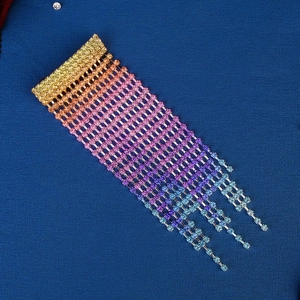 Detailed close-up of rainbow gradient rhinestone tassel clip with colorful diamonds
