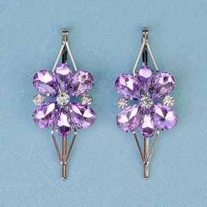 Detail view of purple crystal floral hair clips with silver metal and white rhinestones