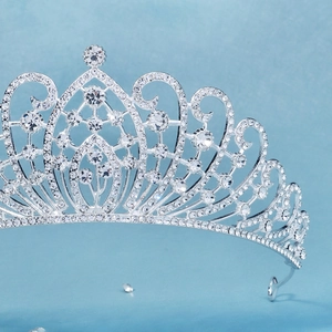 Close-up of elegant silver bridal tiara featuring intricate scrollwork and sparkling rhinestones