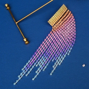 Detail of colorful gradient rhinestone long tassels with vibrant rainbow crystals