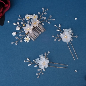 Exquisite bridal hair accessories set with pearl flowers and crystal leaves on blue fabric
