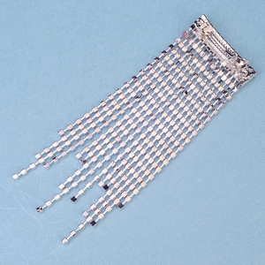 Elegant silver hair clip with long sparkling rhinestone tassels on light blue background