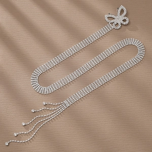 Dettaglio catena in vita con strass argento, motivo a farfalla traforato e lunghe nappe