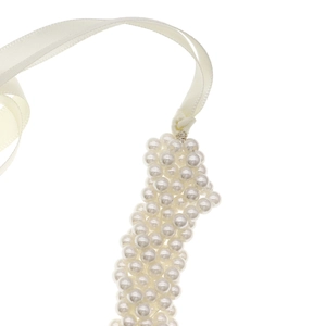 Close-up of handmade pearl cluster belt with elegant white satin ribbon ties