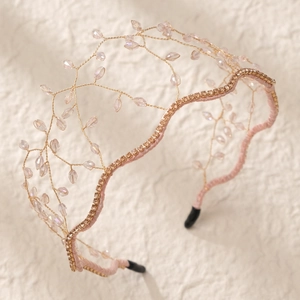 Detailed macro of crystal beads and gold wire on the pink crown headband for parties