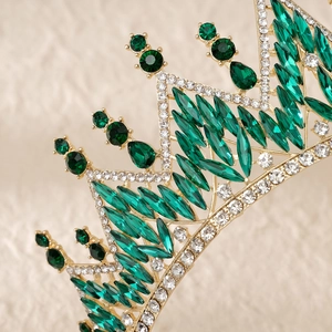 Macro shot of green marquise gems and white rhinestones on vintage gold bridal tiara
