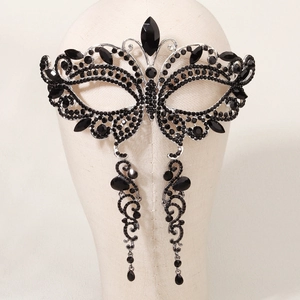 Detail of Gothic black rhinestone eye mask mask with matching tassel earrings on a mannequin