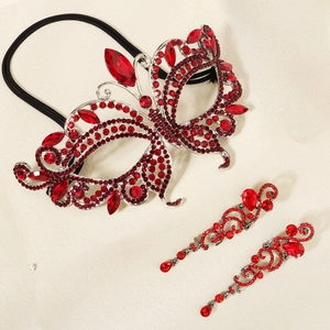 Close-up of red rhinestone butterfly mask and long drop earrings for masquerade ball