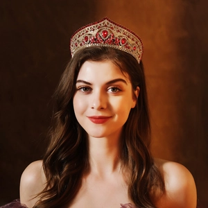 Close-up of a luxury bridal crown with red crystals and gold metal detailing