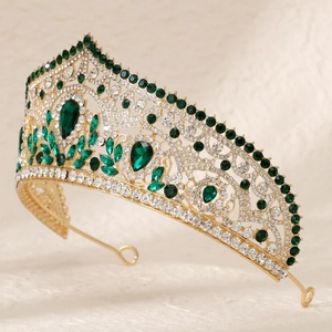 Detailed side view of luxury bridal crown with emerald green stones and golden alloy finish
