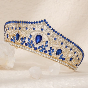 Macro detail of luxury gold bridal crown featuring dark blue teardrop gems and rhinestones