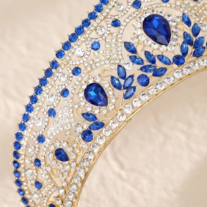Detailed macro of gold bridal crown featuring blue crystals and sparkling rhinestones