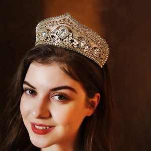 Detailed close-up of a luxurious gold bridal crown with crystals on a model