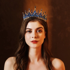 Luxury bridal crown with deep blue crystals and gold metal base in a regal radiant design