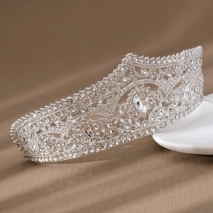 Detailed close-up of luxury bridal crown with red crystals and intricate silver alloy patterns