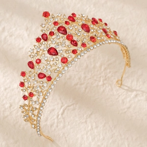 Détail d'une couronne de mariée dorée avec gemmes rouges et cristaux brillants