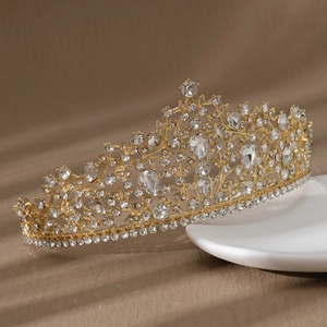 Détail d'une couronne de mariée dorée avec des gouttes de cristal et des strass