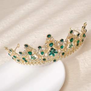 Détail d'une couronne de mariée avec pierres vert émeraude et alliage doré sur plat céramique
